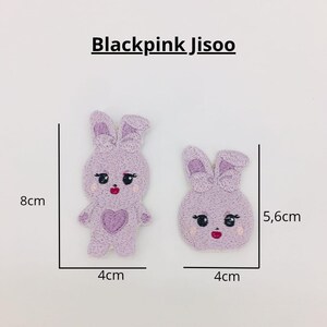 May include: Two purple embroidered bunny patches with pink accents. The larger bunny is 8 cm tall and 4 cm wide. The smaller bunny is 5.6 cm tall and 4 cm wide.