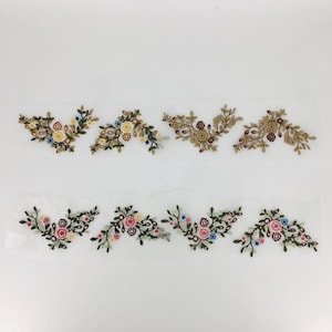 May include: Six embroidered floral appliques in two different color schemes. The top row features appliques with brown, yellow, and blue flowers. The bottom row features appliques with pink, yellow, and blue flowers.