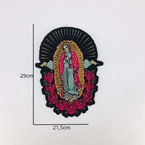 May include: An embroidered patch featuring a depiction of the Virgin Mary with a halo, surrounded by pink roses. The patch is 21.5 cm wide and 29 cm tall.