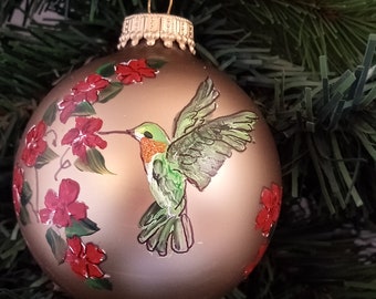 Green hummingbird in the flowers on a gold satin glass round ornament; hand painted, direct from artist.