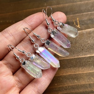 K&ouml;nnte beinhalten: Ein Paar Ohrringe aus schimmerndem Kristall mit silbernen Haken. Die Kristalle sind klar mit einem Regenbogen-Schimmer.