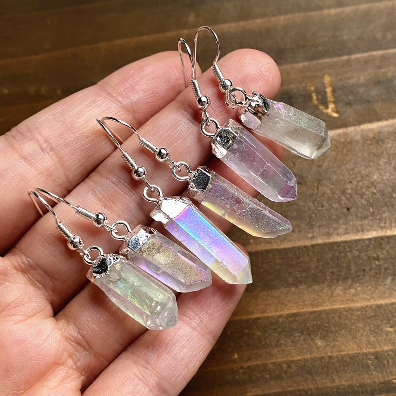 K&ouml;nnte beinhalten: Ein Paar Ohrringe aus schimmerndem Kristall mit silbernen Haken. Die Kristalle sind klar mit einem Regenbogen-Schimmer.