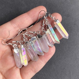 K&ouml;nnte beinhalten: Ein Paar Ohrringe aus schimmerndem Kristall mit silbernen Haken. Die Kristalle sind klar mit einem Regenbogen-Schimmer.