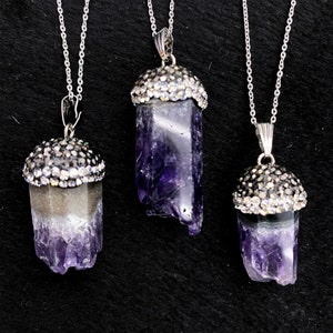 Puede incluir: Tres collares de cadena de plata con colgantes de cristal de amatista. Cada colgante est&aacute; rematado con un bisel de plata engastado con diamantes de imitaci&oacute;n transparentes.