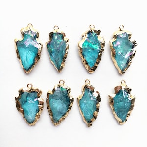 Puede incluir: Ocho colgantes de cristal en forma de punta de flecha de color azul turquesa con detalles de lámina dorada. Los colgantes miden aproximadamente 5 cm de largo.