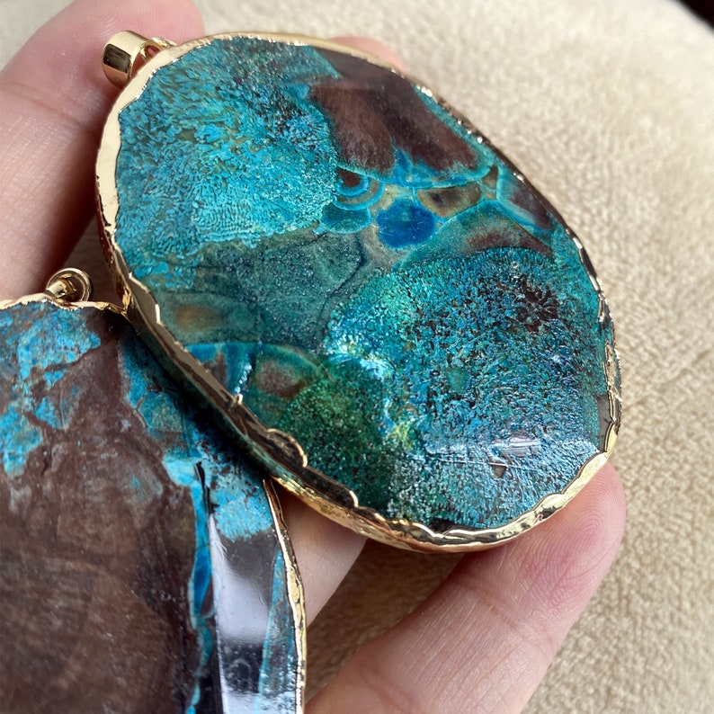 May include: Two large, round, turquoise and brown agate pendants with gold-toned edges. The pendants have a unique, marbled pattern.