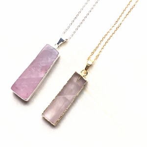 May include: Two necklaces with rose quartz pendants. One necklace has a silver chain and the other has a gold chain.
