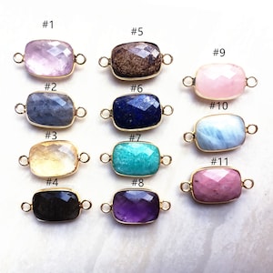 Può includere: Undici diversi ciondoli connettore in pietra preziosa con accenti in metallo dorato. I ciondoli sono rettangolari e presentano vari colori, tra cui rosa, blu, verde, marrone e viola.