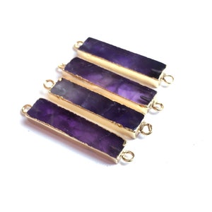 May include: Four purple amethyst bar connectors with gold-plated edges and jump rings. The connectors are arranged in a row, with the largest connector at the bottom and the smallest connector at the top.