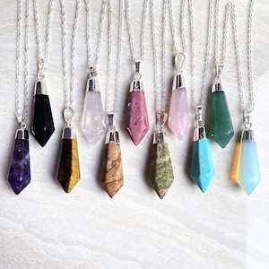 Puede incluir: Diez collares de plata con colgantes de piedras preciosas de diferentes colores. Los colgantes tienen todos forma de punta, y las piedras preciosas son amatista, ojo de tigre, jaspe marrón, aventurina verde, turquesa, ópalo, obsidiana negra, cuarzo rosa, rodonita rosa y aventurina verde.