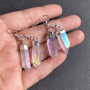 K&ouml;nnte beinhalten: Ein Paar Ohrringe aus schimmerndem Kristall mit silbernen Haken. Die Kristalle sind klar mit einem Regenbogen-Schimmer.