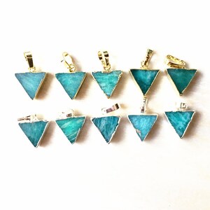 Pode incluir: Doze pingentes triangulares de aventurina verde com aro dourado. Cada pingente tem um laço na parte superior para prender a uma corrente ou cordão.
