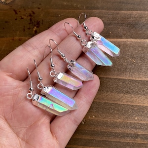 K&ouml;nnte beinhalten: Ein Paar Ohrringe aus schimmerndem Kristall mit silbernen Haken. Die Kristalle sind klar mit einem Regenbogen-Schimmer.