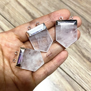 Puede incluir: Tres colgantes de cristal de cuarzo transparente con tapas de metal plateadas y anillas de salto. Los cristales son facetados y tienen una apariencia transl&uacute;cida.