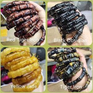 Op de afbeelding: Vier armbanden van natuursteen worden getoond. De armbanden zijn gemaakt van rood tijgerijzer, zwarte obsidiaan, gele jade en tijgerijzer. Elke armband is gemaakt van cilindrische kralen die aan elkaar zijn geregen. De tekst op de afbeelding identificeert elk steentype.