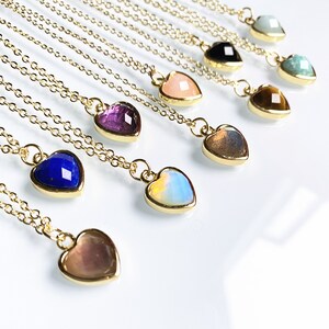 Puede incluir: Un conjunto de collares de oro con colgantes en forma de corazón con varias piedras preciosas, incluyendo amatista, ópalo, lapislázuli y ojo de tigre.