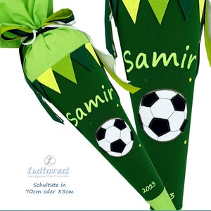 May include: Two green and yellow school cones with a soccer ball design. The cones are personalized with the name "Samir" and the year "2023".