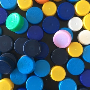 100 KUNSTSTOF DOPPEN/ plastic flesdeksels gerecycled