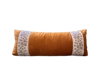 Cojín lumbar largo de terciopelo color caramelo de lujo con ribete bordado floral.