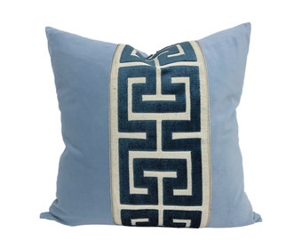 May include: A light blue throw pillow with a white and teal geometric pattern down the center.