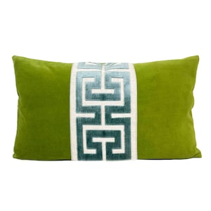 May include: Green velvet pillow with a blue and white geometric pattern down the center.