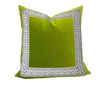 Puede incluir: Almohada de terciopelo verde con un borde de llave griega gris y blanco.