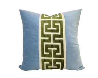 May include: A light blue velvet pillow with a green and white geometric pattern down the center.