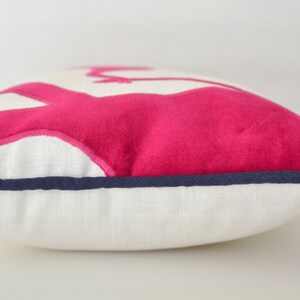 Op de afbeelding: Een wit kussen met een roze vilt applique van een flamingo. Het kussen heeft een donkerblauwe rand.