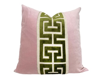 Op de afbeelding: Een roze fluwelen kussen met een groene en witte geometrische rand.
