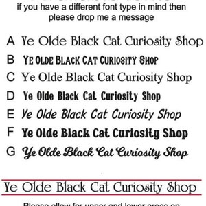 May include: A list of different font styles for the phrase "Ye Olde Black Cat Curiosity Shop". The fonts are labeled A through G. The text at the bottom of the image reads "Please allow for upper and lower areas on fonts when measuring your area as shown by red lines."