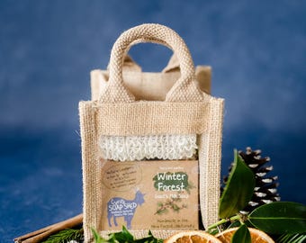 Può includere: Una piccola borsa di iuta con manico, contenente una saponetta al latte di capra con l'etichetta "Winter Forest". La borsa è decorata con fette d'arancia essiccate, aghi di pino e un bastoncino di cannella. Il sapone è fatto a mano.