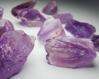 May include: A collection of amethyst crystals in various shapes and sizes. The crystals are a deep purple color and have a natural, rough texture.