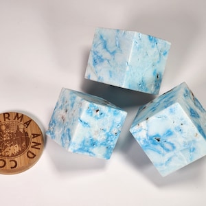 May include: Three blue and white marbled cubes with a wooden round disc with the text "COBAL KARMA AND" engraved on it.