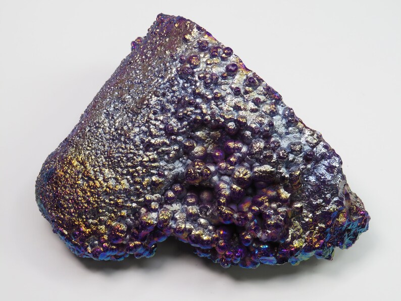 May include: A large, iridescent, purple and gold, agate geode with a rough, textured surface. The geode has a unique, bubbly appearance.