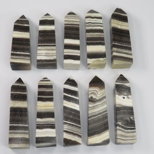 May include: Twelve black and white striped obelisk shaped crystal points. The points are approximately 2 inches in length.