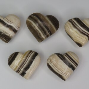 May include: Five brown and white striped heart-shaped polished stones.