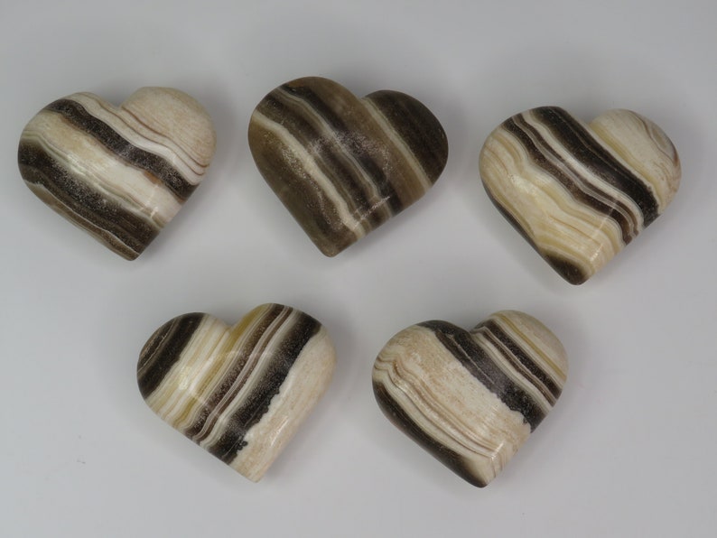 May include: Five brown and white striped heart-shaped polished stones.