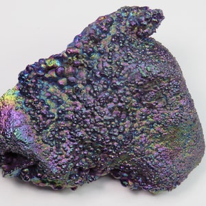 May include: A large, iridescent, purple and blue, rough, natural, mineral specimen with a bumpy, textured surface.