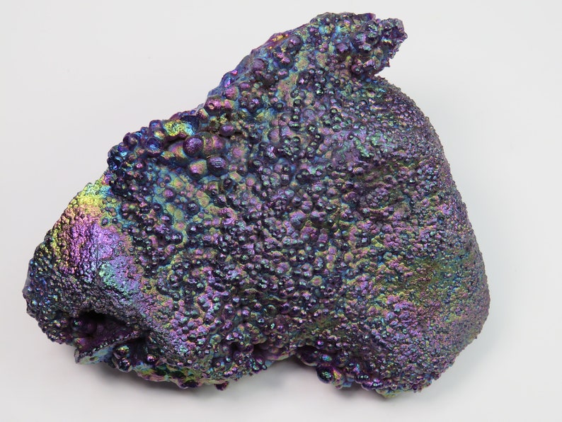 May include: A large, iridescent, purple and blue, rough, natural, mineral specimen with a bumpy, textured surface.