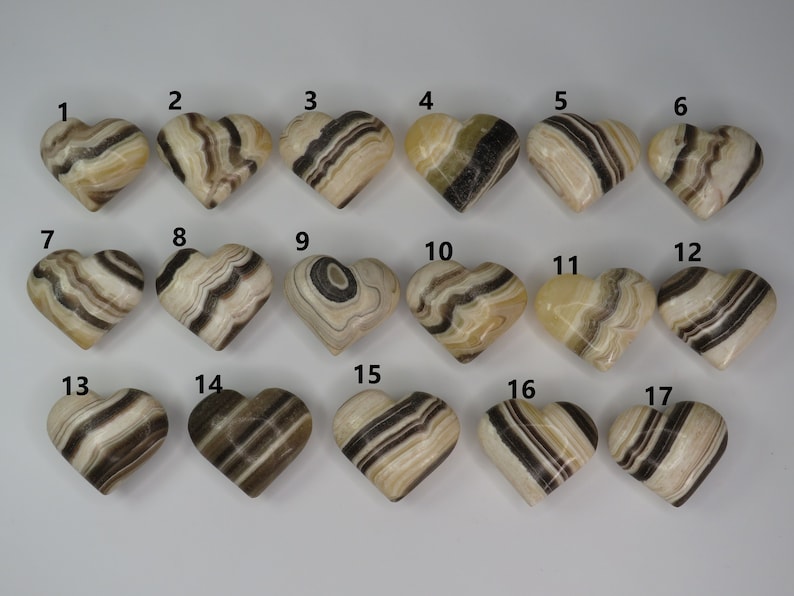 May include: Seventeen heart-shaped polished stones with black and white stripes. The stones are numbered 1 through 17.