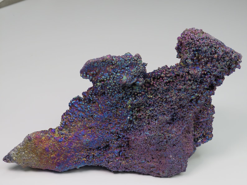 May include: A large, iridescent, purple and blue goethite specimen with a rough, textured surface. The mineral has a unique, bubbly appearance.