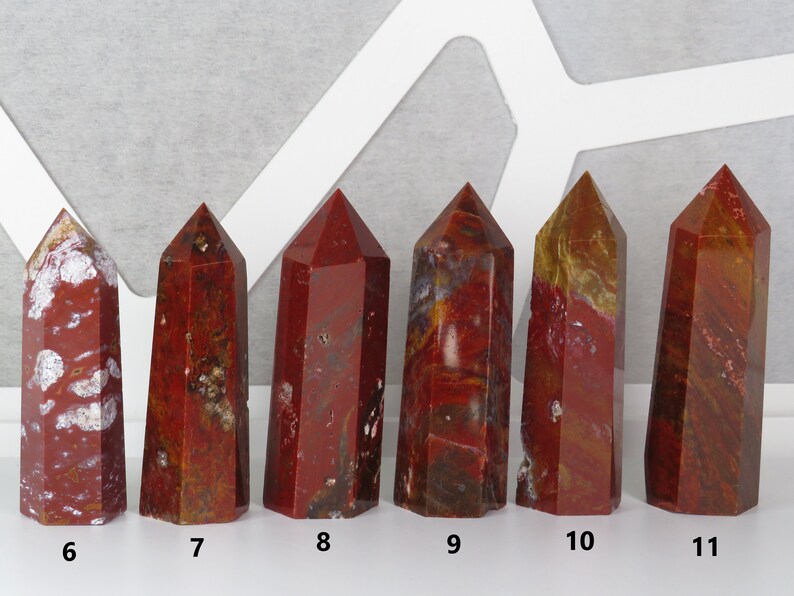 May include: Six red, brown, and white jasper crystal points, arranged in a row from left to right, numbered 6 through 11.