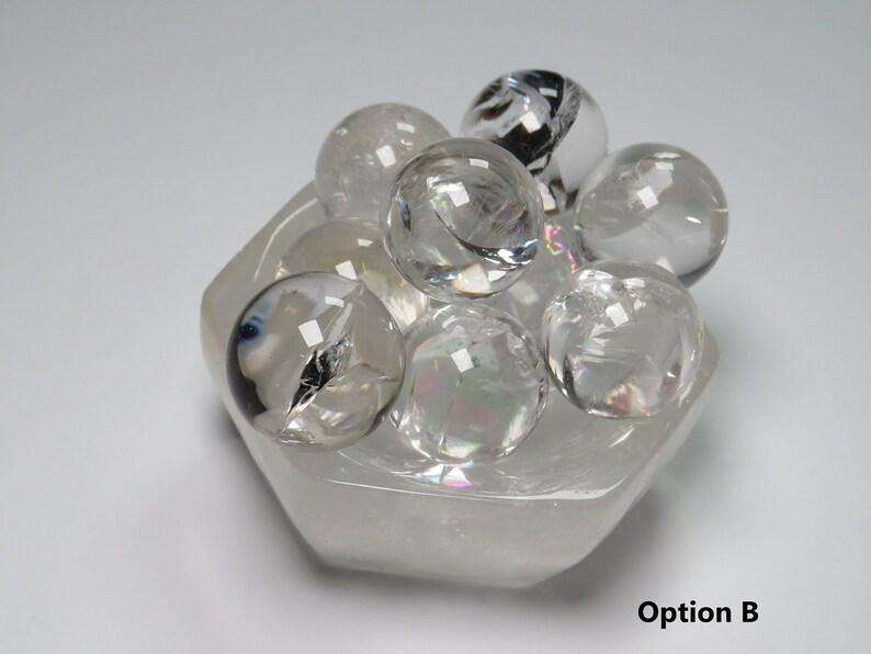 May include: A cluster of clear quartz crystal spheres in a hexagonal clear quartz crystal bowl. Option B.