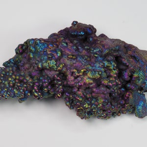May include: A large, iridescent, purple, blue, and green, mineral specimen with a bubbly, textured surface.