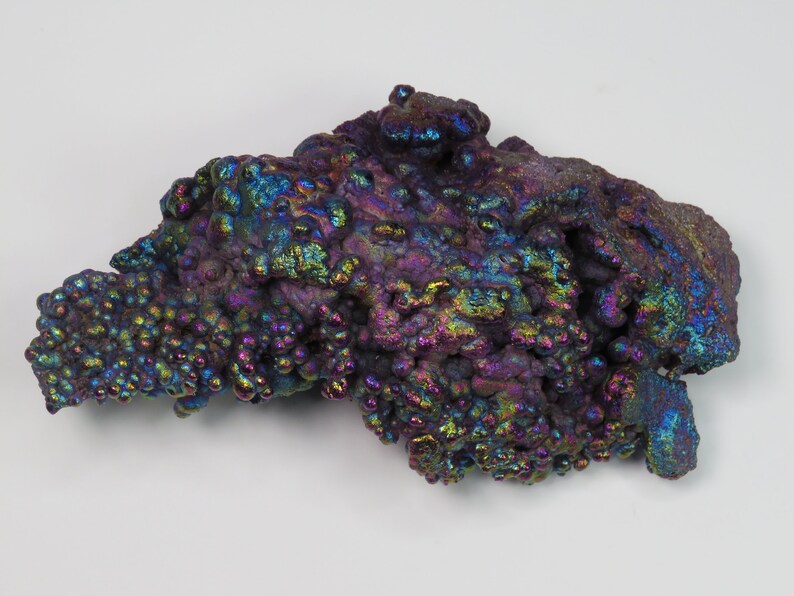 May include: A large, iridescent, purple, blue, and green, mineral specimen with a bubbly, textured surface.