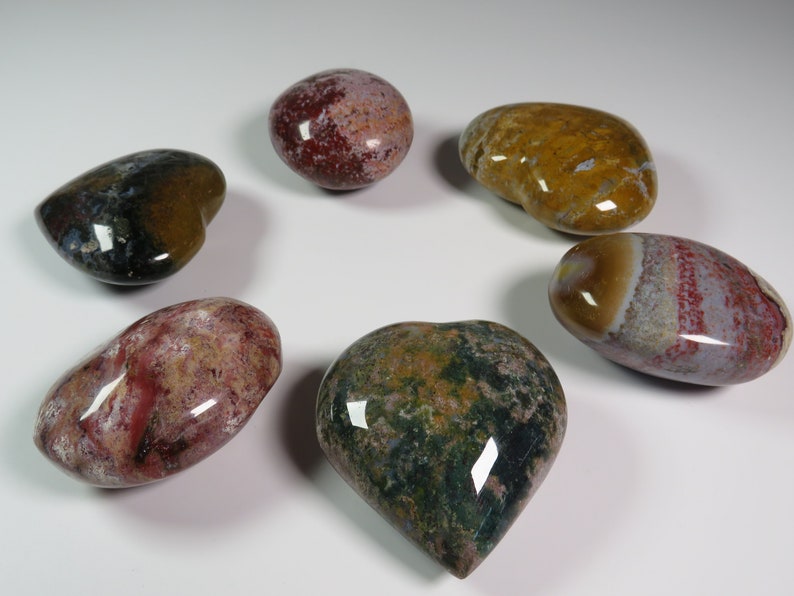 May include: Six heart-shaped polished stones with various patterns and colours, including red, green, brown, and white.