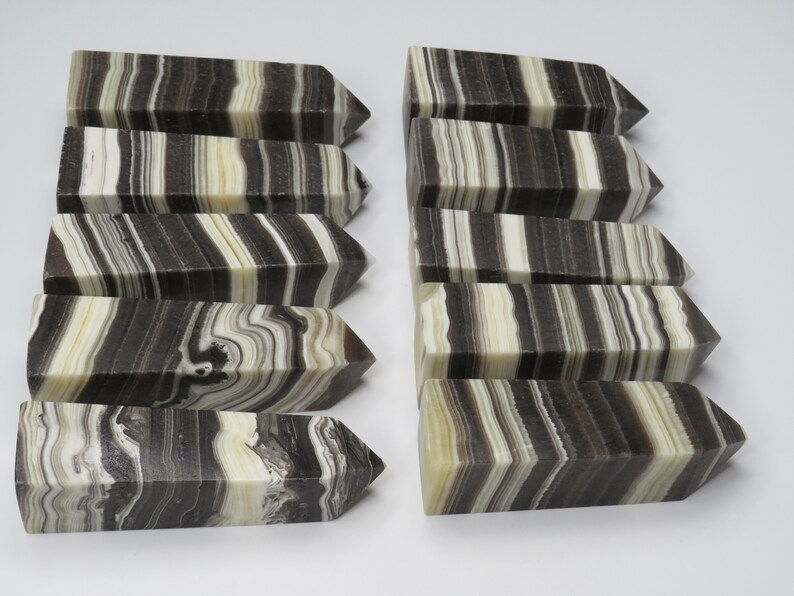 May include: Ten black and white striped onyx crystal points. The points are polished and have a smooth, glossy finish. The stripes are natural and vary in width and color.
