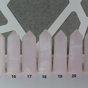 May include: Eight pink crystal towers of varying heights, numbered 15 through 21. The towers are arranged in a row on a white surface.