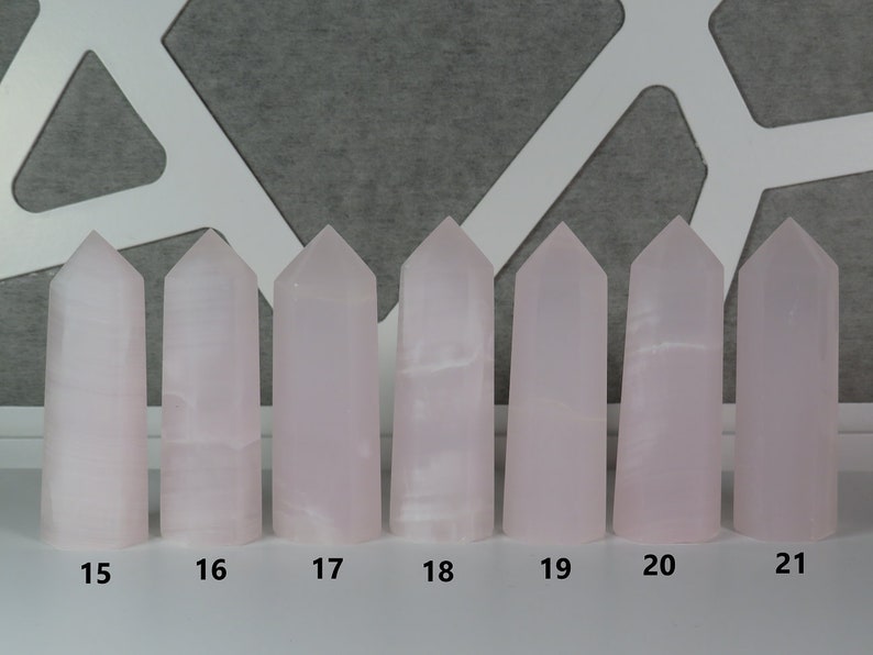 May include: Eight pink crystal towers of varying heights, numbered 15 through 21. The towers are arranged in a row on a white surface.