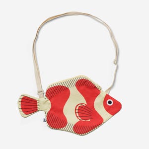Könnte beinhalten: Eine rot-weiße, fischförmige Umhängetasche mit einem cremefarbenen Riemen. Die Tasche hat einen Reißverschluss und einen schwarzen und weißen Umriss.